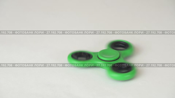 Green fidget spinner turns and stops on white background stock footage video. Стоковое видео, видеограф Юлия Машкова / Фотобанк Лори