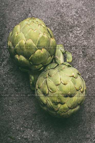 Green organic artichokes on gray granite table, top view. Healthy dieting and antioxidant vegetables. Стоковое фото, агентство Ingram Publishing / Фотобанк Лори