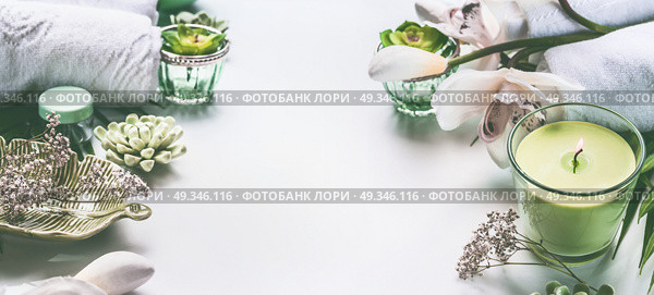 Green spa or wellness background with towels, candle, orchid flowers and body and face care tools and accessories on white desktop, top view with copy space, frame. Стоковое фото, агентство Ingram Publishing / Фотобанк Лори