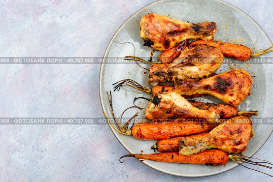 Grilled chicken drumsticks, roast chicken legs with carrots. Space for text.. Baked chicken drumstick. Стоковое фото, агентство Ingram Publishing / Фотобанк Лори