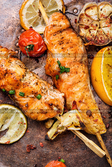Grilled fish, grilled salmon steak with addition of lemon. Grilled salmon on skewer. Стоковое фото, агентство Ingram Publishing / Фотобанк Лори