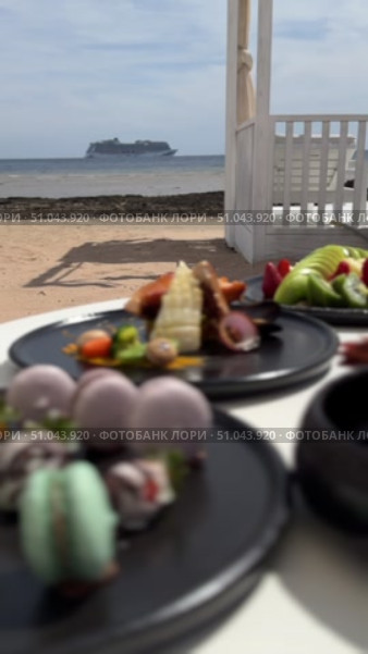 Grilled salmon steak with crispy skin sauteed vegetables and lemon served in outdoor restaurant in summer light A wooden table with a variety of dishes containing seafood, vegetables and fruit.Hand holding a spoon ready to eat pineapple fried rice with shrimp, served in a pineapple bowl, surrounded by fresh fruits and tea on a cozy table setting.Party Sea Food platter with salmon and prawns, low angle view, close-up Sea food party platter, extreme Whole poached salmon with cucumber slices for scales, high end party platter, overhead view Tiger prawns on the grill Macarooni cookies floating on blue background, levitation, macarooni cookies, dessert, sweets, colorful, delicious Two Glasses of Pink Champagne with Macarons and Oranges Elegant seaside celebration with seafood, pink floral decor, and sparkling wine overlooking the ocean. Стоковое видео, видеограф Zita Khasanova / Фотобанк Лори