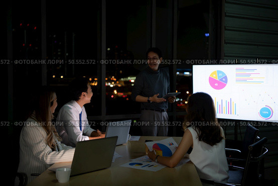 Group of broker international stock traders working actively at night in office, Everyone is striving for the team’s success. Стоковое фото, агентство Ingram Publishing / Фотобанк Лори
