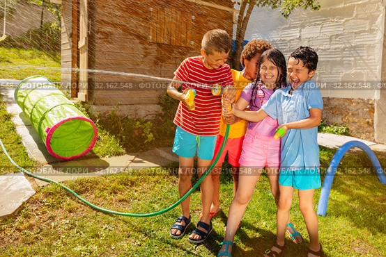 Group of children fight with water gun and spray. Стоковое фото, фотограф Сергей Новиков / Фотобанк Лори