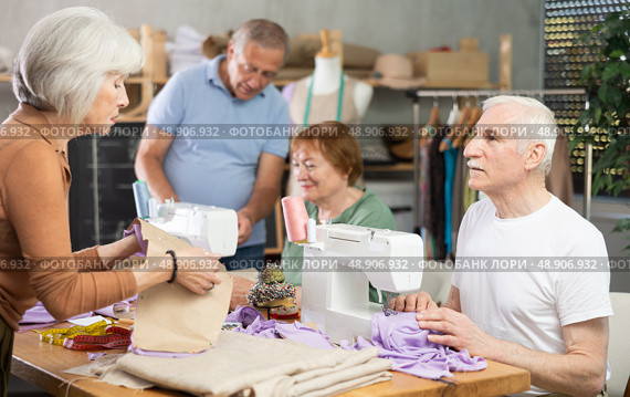 Group of senior learners enjoying sewing class in workshop. Стоковое фото, фотограф Яков Филимонов / Фотобанк Лори