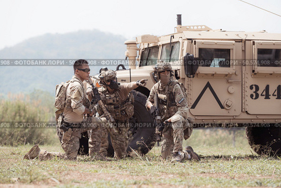 Group of soldiers in camouflage uniforms hold weapons in a jltv car, Plan and prepare for combat training. Стоковое фото, агентство Ingram Publishing / Фотобанк Лори