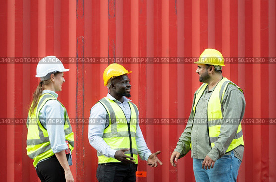 Group of workers in a container storage yard greeting each other during breaks in front of container warehouse, Стоковое фото, агентство Ingram Publishing / Фотобанк Лори