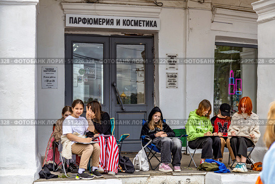Группа подростков с планшетами занимаются рисованием в "Красных рядах" Костромы летом. Редакционное фото, фотограф Владимир Шипикин / Фотобанк Лори