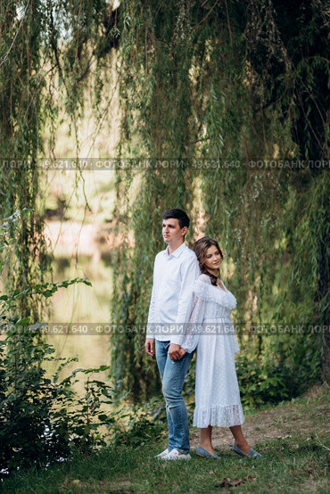 guy and a girl walk along the paths of a forest park between tall trees. Стоковое фото, агентство Ingram Publishing / Фотобанк Лори