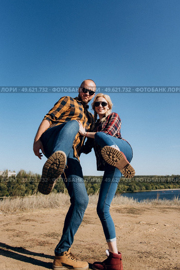 Guy and girl in caged shirts and trekking shoes on granite rocks. Стоковое фото, агентство Ingram Publishing / Фотобанк Лори