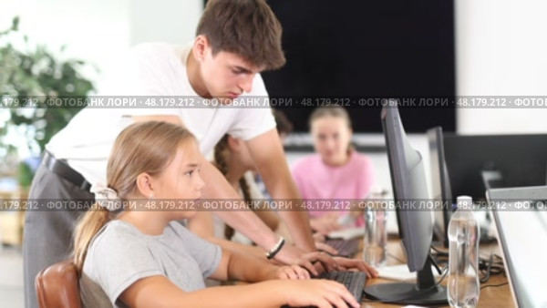 Guy teacher teaches girl student how to use computer. Стоковое видео, видеограф Яков Филимонов / Фотобанк Лори