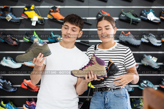 Guy with girlfriend, view specialized shoes in store, near showcase with summer trecking cross-shoes. Стоковое фото, фотограф Яков Филимонов / Фотобанк Лори