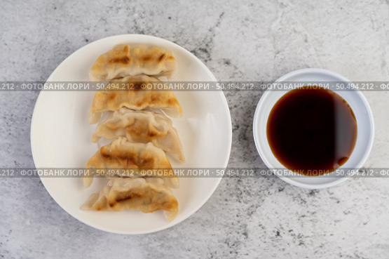 Gyoza beautifully arranged in a white plate with sauce. Стоковое фото, агентство Ingram Publishing / Фотобанк Лори