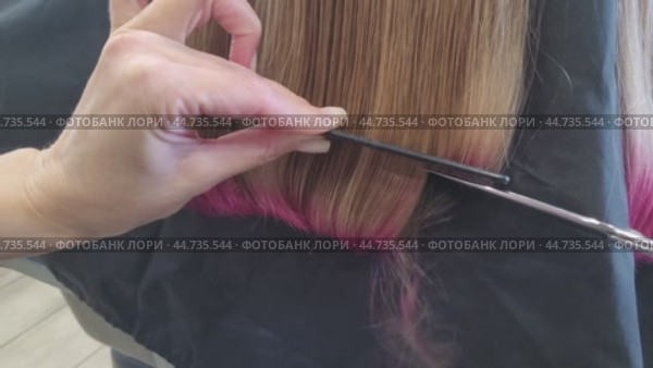 Hairdresser shortening hair length, trimming it with scissors, cutting off part of dyed hair. Стоковое видео, видеограф Сергей Чайко / Фотобанк Лори