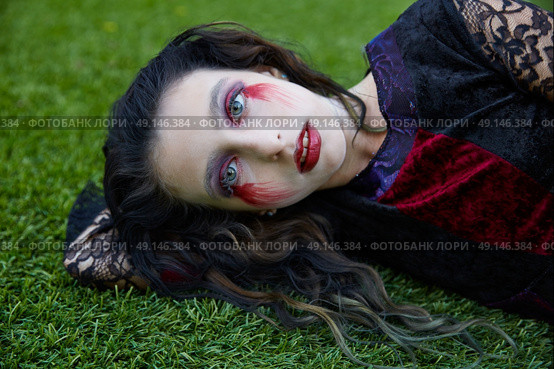 Halloween kid girl custome with bloody makeup on backyard turf. Стоковое фото, агентство Ingram Publishing / Фотобанк Лори
