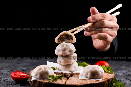 hand holding chopsticks with dumpling. Стоковое фото, агентство Ingram Publishing / Фотобанк Лори