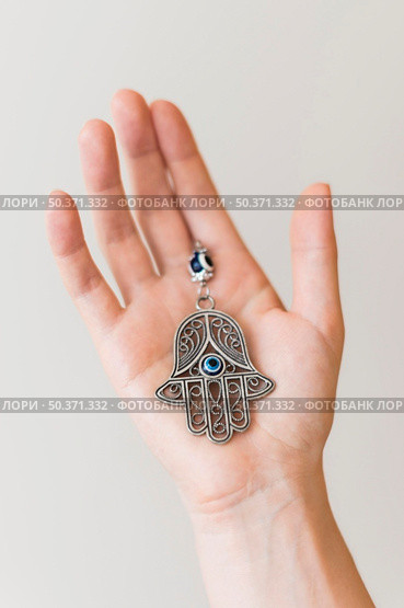 hand holding hamsa pendant. Стоковое фото, агентство Ingram Publishing / Фотобанк Лори