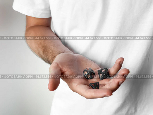 Hand holding polyhedral dice for tabletop gaming and role-playing games. Стоковое фото, фотограф Lamina Akulova / Фотобанк Лори