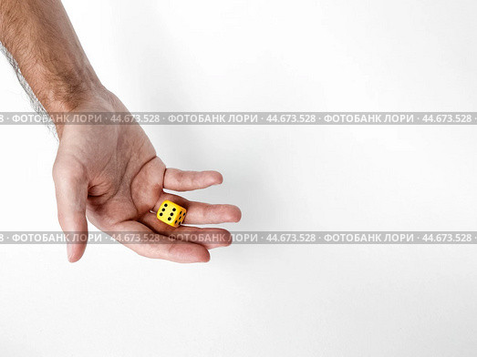 Hand holding yellow dice on white background. Стоковое фото, фотограф Lamina Akulova / Фотобанк Лори