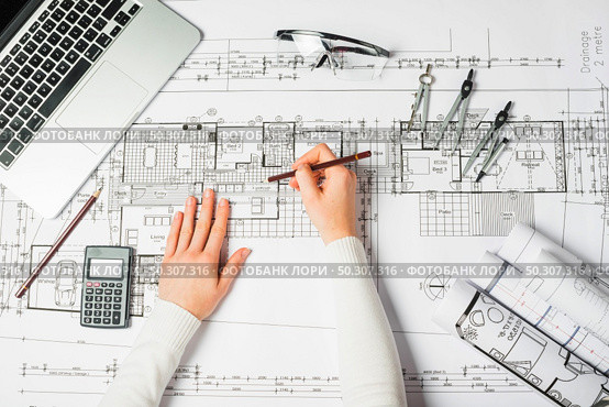 Hand over Construction plans with yellow helmet and drawing tools on blueprints. Hand over Construction plans with yellow helmet and drawing tools on blueprints . Стоковое фото, агентство Ingram Publishing / Фотобанк Лори