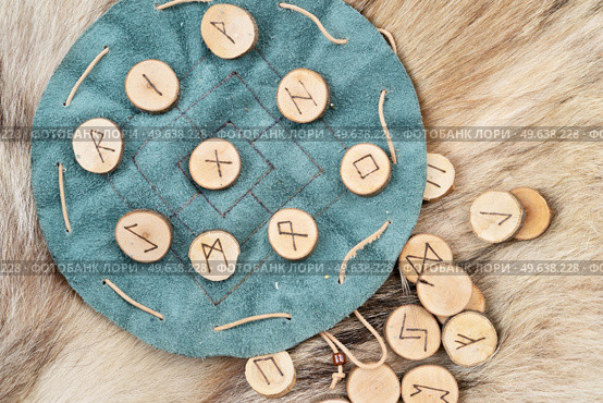 Handmade runes for fortunetelling over green leather chart. Handmade runes for fortunetelling. Стоковое фото, агентство Ingram Publishing / Фотобанк Лори