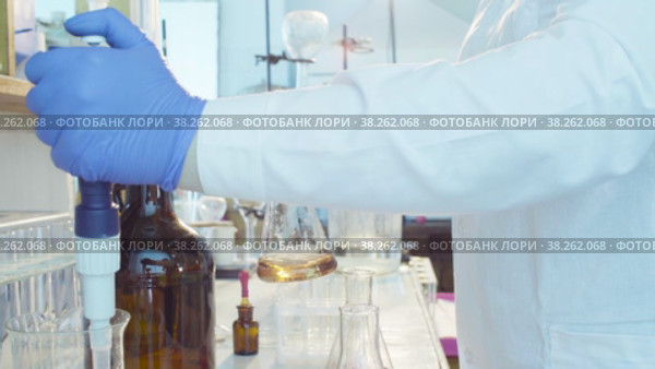 Hands of a scientist titrating solution. Стоковое видео, видеограф Chudakov_Ivan / Фотобанк Лори