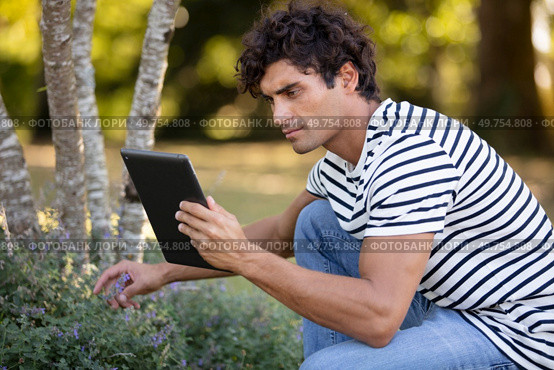 handsome man holding a tablet looking for plant references. Стоковое фото, агентство Ingram Publishing / Фотобанк Лори