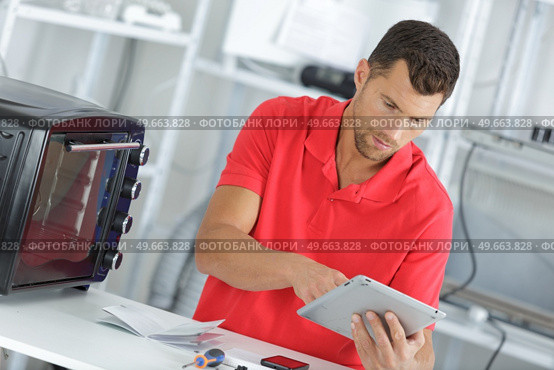 handsome repairer gathering informations on internet. Стоковое фото, агентство Ingram Publishing / Фотобанк Лори