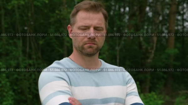 Handsome young man standing outdoors. Male thinking looking around feel happy, calm and serious. Green park background. Guy business employer, businessman manager inspired in nature. Diversity People. Стоковое видео, видеограф Марина Демидюк / Фотобанк Лори