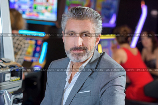 handsome young man with slot machine in the casino. Стоковое фото, агентство Ingram Publishing / Фотобанк Лори