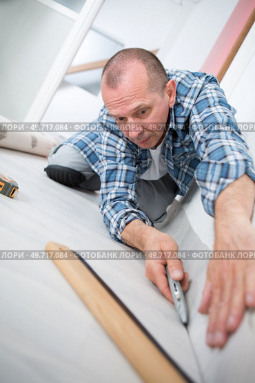 handyman installing new layered wooden parquet. Стоковое фото, агентство Ingram Publishing / Фотобанк Лори