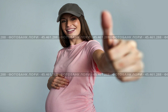 Happy and cheerful young pregnant woman in a baseball cap. Стоковое AI-изображение, AI-художник Дмитрий Киселёв / Фотобанк Лори