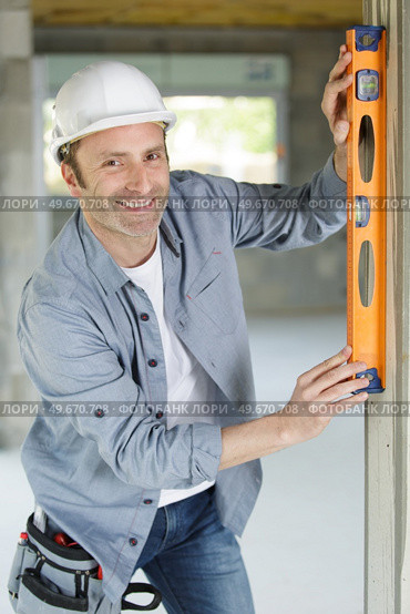 happy builder using a level n. Стоковое фото, агентство Ingram Publishing / Фотобанк Лори