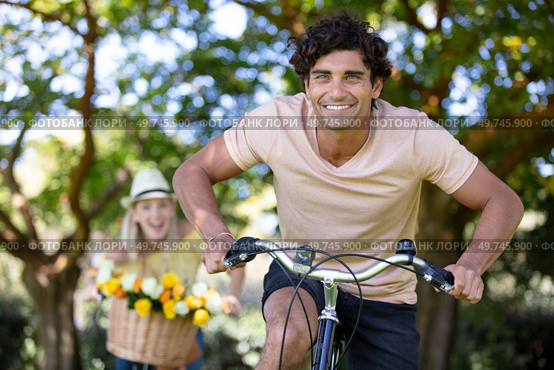 happy couple chasing each other on bike. Стоковое фото, агентство Ingram Publishing / Фотобанк Лори