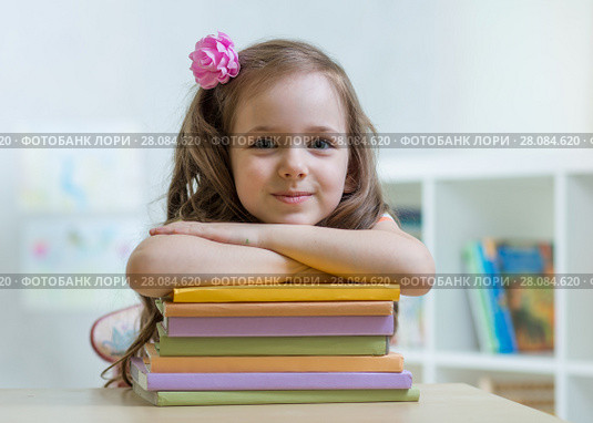 Happy kid girl with a stack of books at home. Стоковое фото, фотограф Оксана Кузьмина / Фотобанк Лори