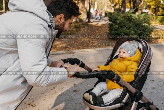 happy man with his child outdoors stroller. Стоковое фото, агентство Ingram Publishing / Фотобанк Лори
