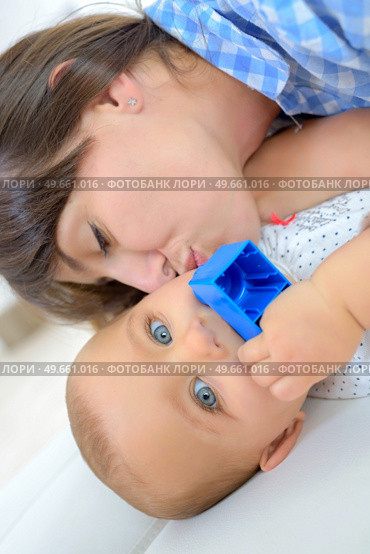 happy mother with baby lying on bed at home. Стоковое фото, агентство Ingram Publishing / Фотобанк Лори