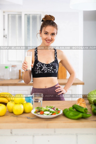 Happy slim sporty girl drinking yogurt in home kitchen. Стоковое фото, фотограф Татьяна Яцевич / Фотобанк Лори