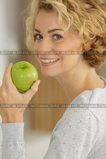 happy woman biting a green apple. Стоковое фото, агентство Ingram Publishing / Фотобанк Лори