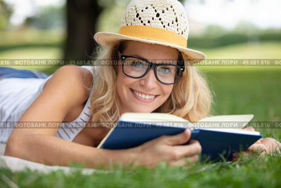 happy woman enjoys reading a book in the garden. Стоковое фото, агентство Ingram Publishing / Фотобанк Лори