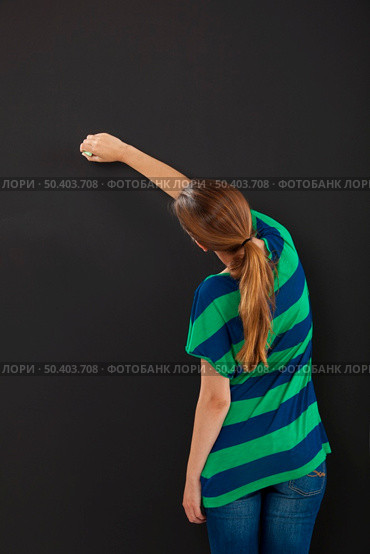 Happy woman writing on  chalkboard, with copy space for designer. Стоковое фото, агентство Ingram Publishing / Фотобанк Лори