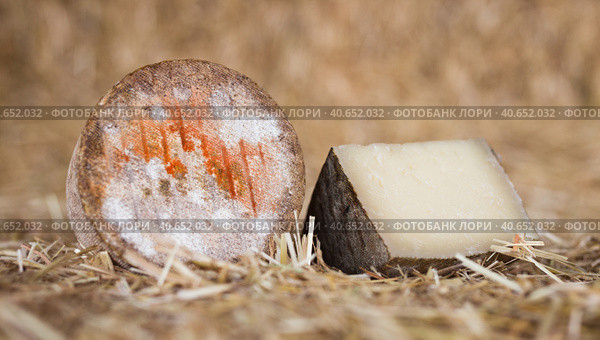 head and chunks of aged hard cheese in hayloft. Стоковое фото, фотограф Татьяна Яцевич / Фотобанк Лори