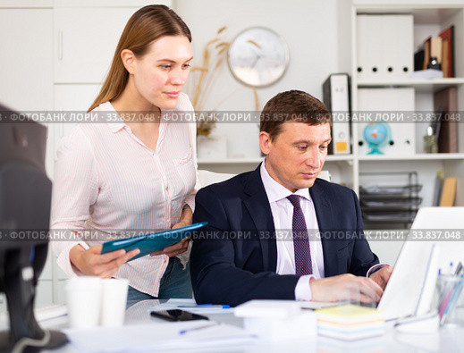 Head gives task to assistant at office at table. Стоковое фото, фотограф Яков Филимонов / Фотобанк Лори