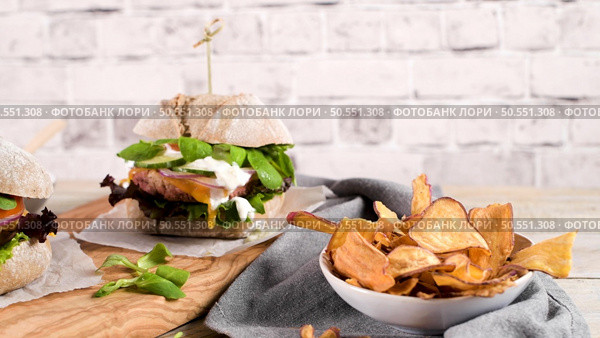 Healthy vegan burger with fresh vegetables and yogurt sauce on rustic kitchen counter top. Стоковое фото, агентство Ingram Publishing / Фотобанк Лори