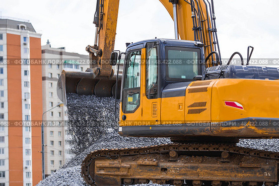 Heavy machinery for construction and landscaping. An excavator on a construction site in close-up. An excavator loads crushed stone into a bucket for construction. Стоковое фото, фотограф Photojuli / Фотобанк Лори