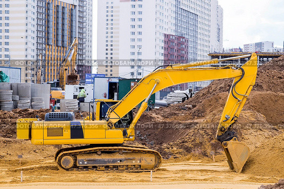 Heavy machinery for excavation and landscaping. Close-up view of an excavator at a construction site. The excavator excavates the soil for excavation and construction. Стоковое фото, фотограф Photojuli / Фотобанк Лори