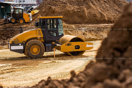 Heavy machinery for excavation and landscaping. Close-up of a road roller on a construction site in the sand. Excavation and road construction. Стоковое фото, фотограф Photojuli / Фотобанк Лори