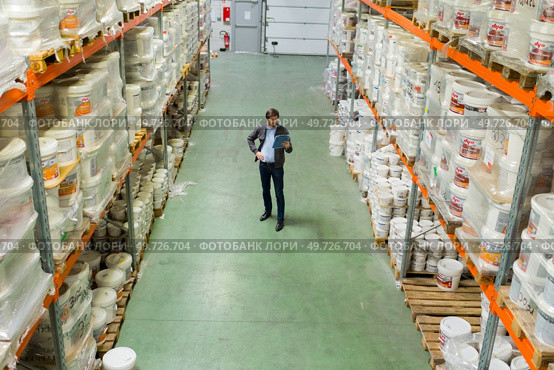 high angle view of man between racking in warehouse. Стоковое фото, агентство Ingram Publishing / Фотобанк Лори