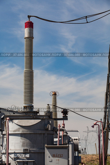 High-voltage transformer, isolator and wires on distributing substation. Blue sky and light clouds background. Стоковое фото, фотограф Alexey Rezvykh / Фотобанк Лори