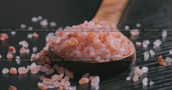 Himalayan pink salt in a wooden is used to flavor food. Due mainly to marketing costs, pink Himalayan salt is up to twenty times more expensive than table or sea salt. Стоковое видео, видеограф Андрей Армягов / Фотобанк Лори
